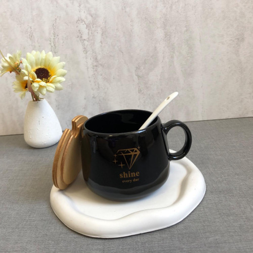 Black mug with wooden lid and spoon